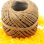 hemp wicks coated in beeswax on top of beeswax pellets