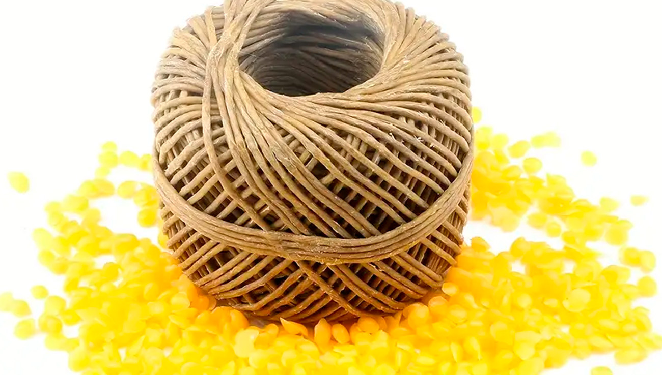 hemp wicks coated in beeswax on top of beeswax pellets