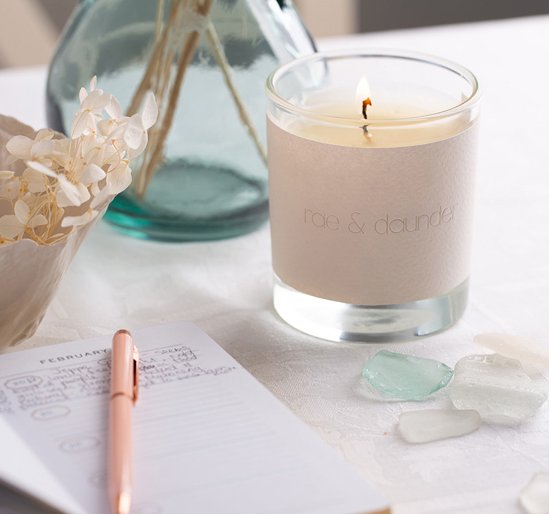 Dandelion candle next to a diary with pen