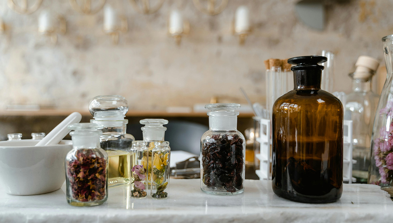 small glass bottles with dried plants or flowers inside