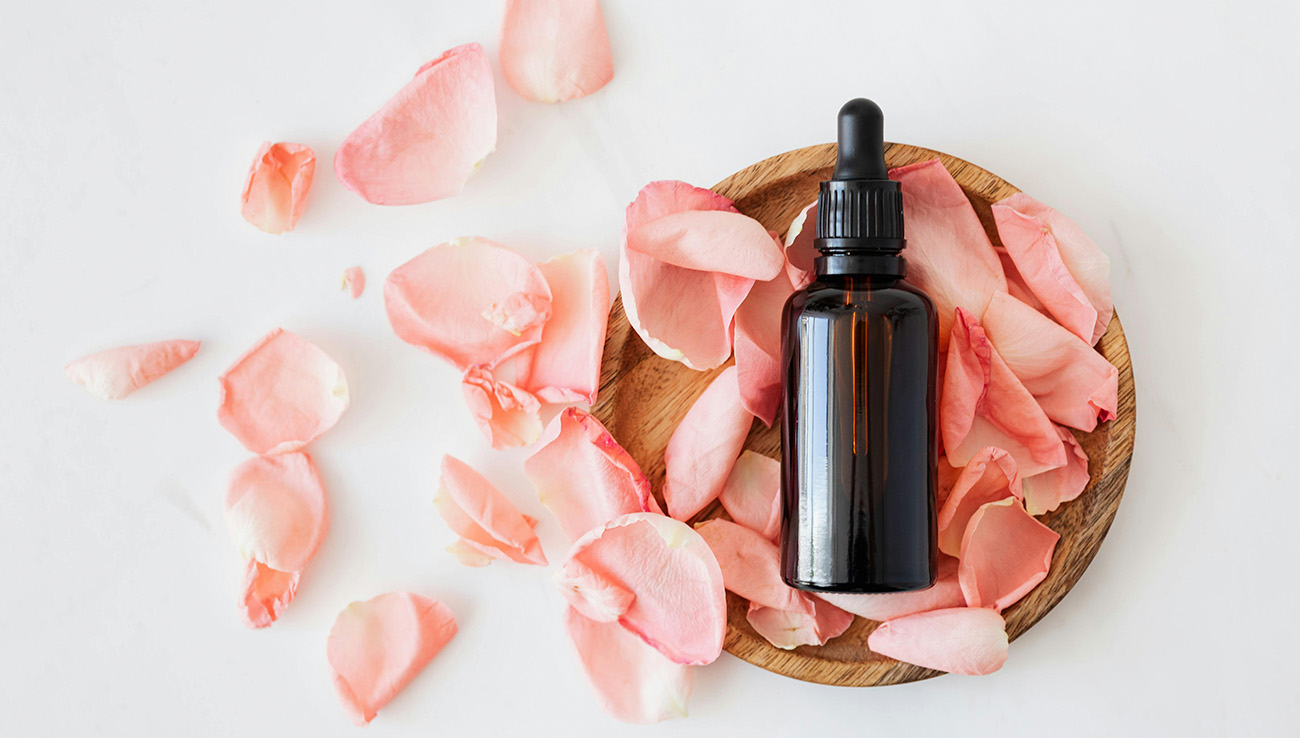 rose petals with brown glass bottle