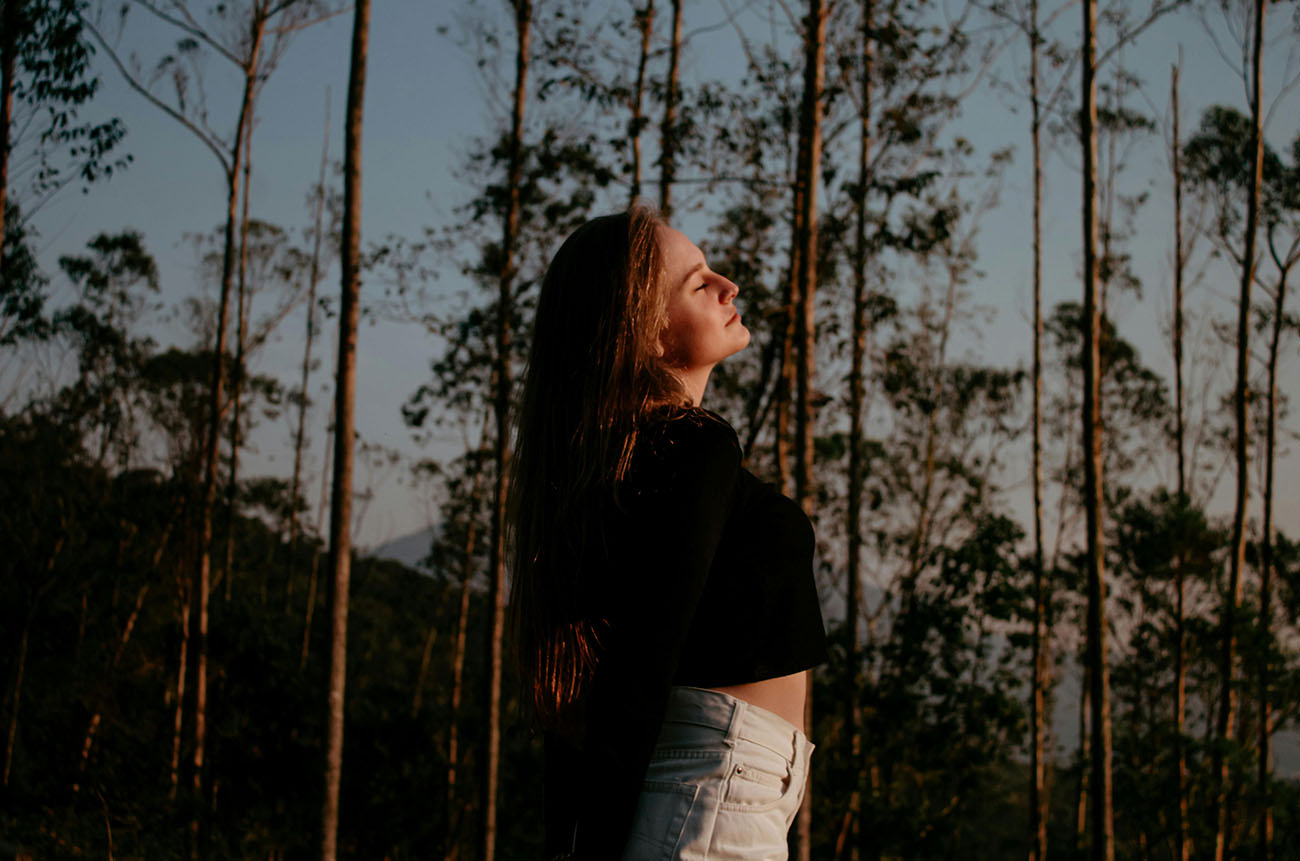 girl enjoying forest bathing surrounded by trees