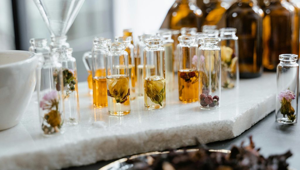 Glass bottles with natural ingredients soaking for candle infusion