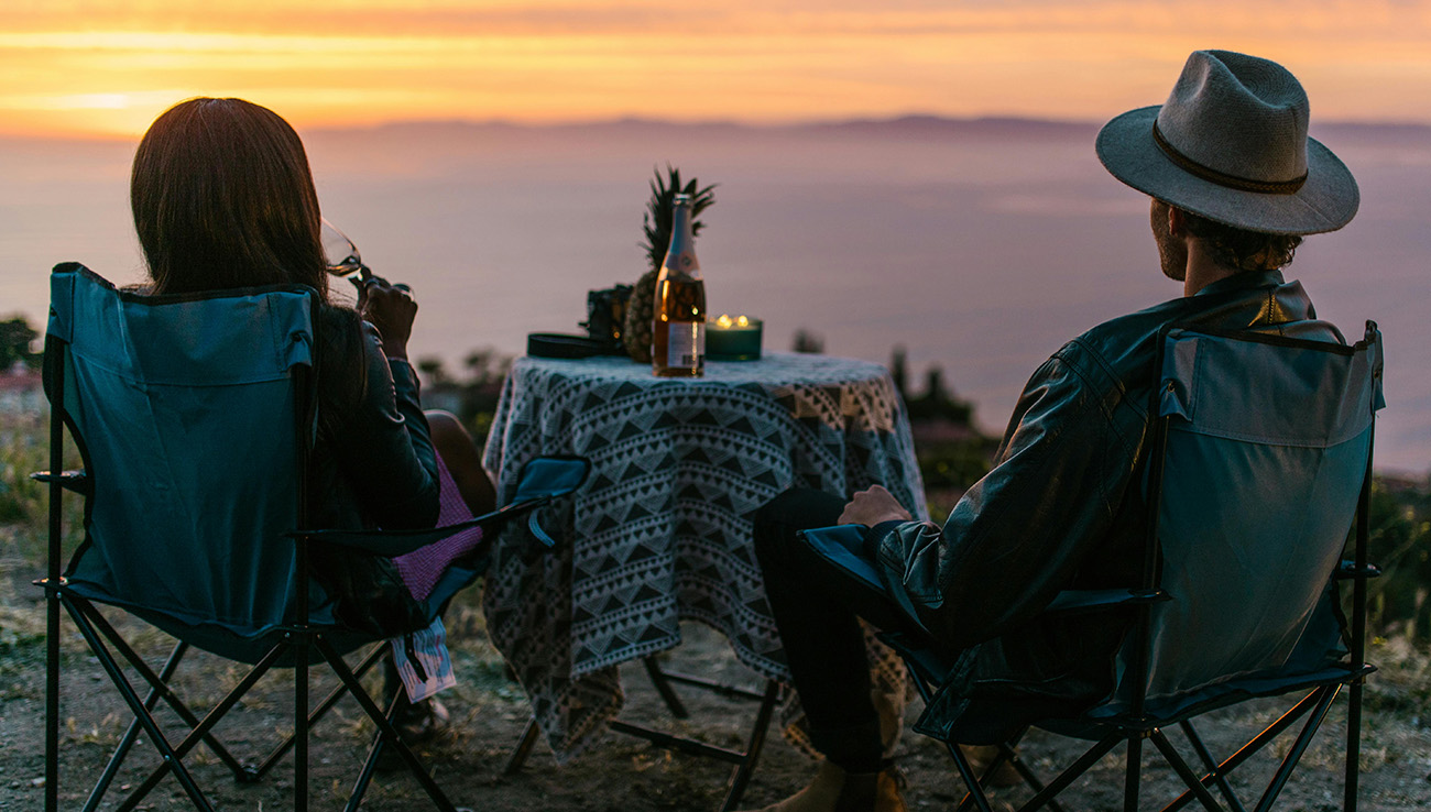 Couple enjoying summer candle rituals outdoors with candlelight at sunset